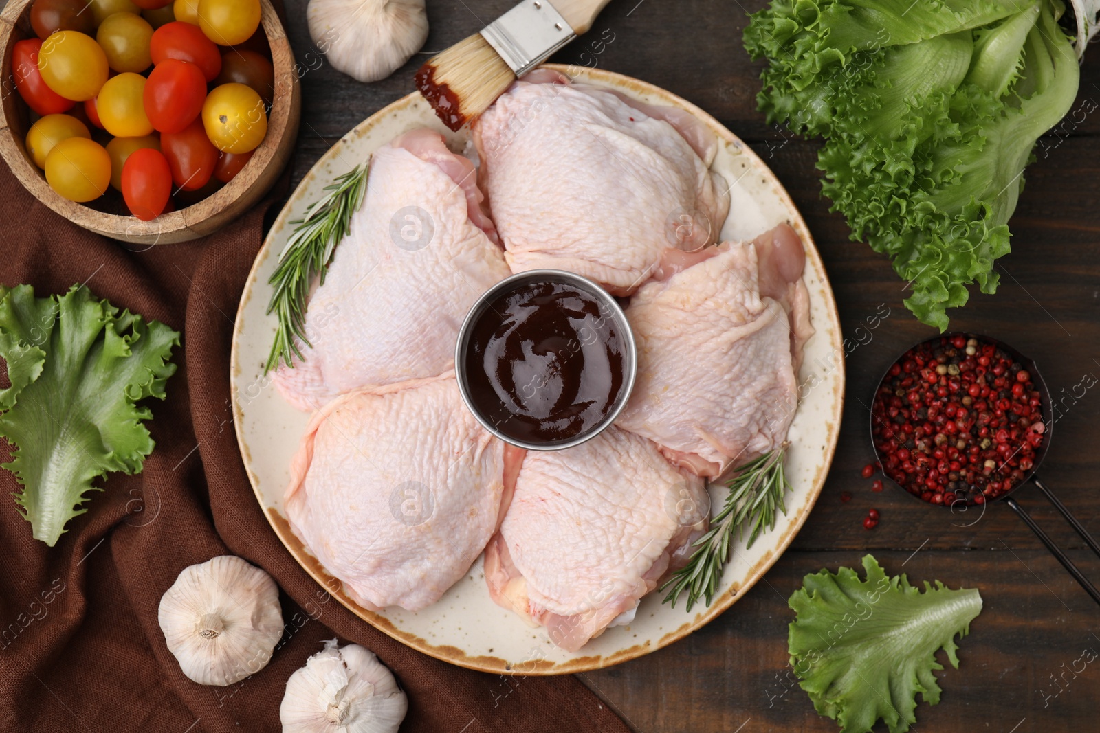 Photo of Flat lay composition with fresh marinade, raw chicken, rosemary and other products on wooden table