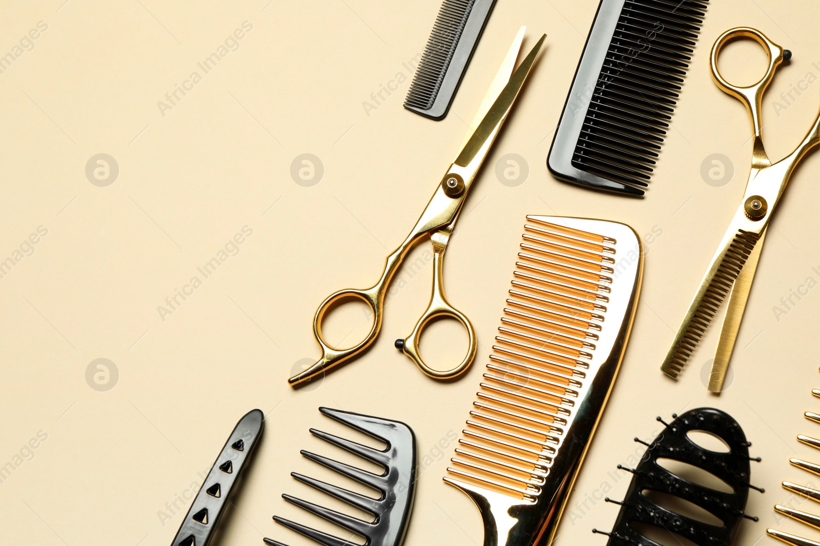 Photo of Hairdressing tools on beige background, flat lay. Space for text