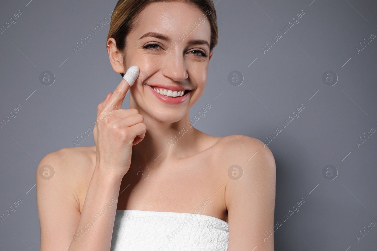 Photo of Woman using silkworm cocoon in skin care routine on grey background. Space for text