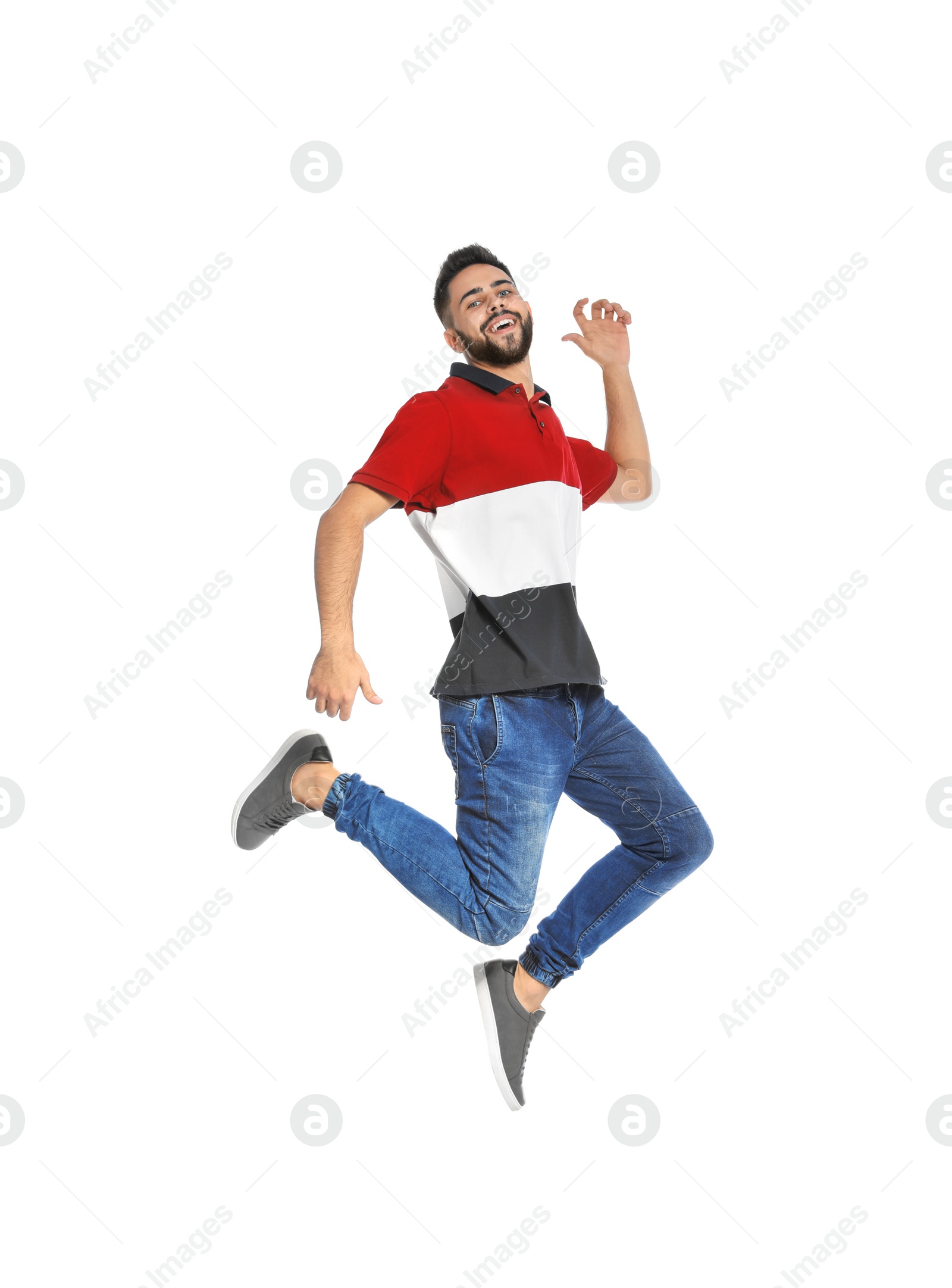 Photo of Handsome young man jumping on white background