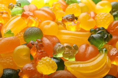 Mix of different delicious gummy candies as background, closeup