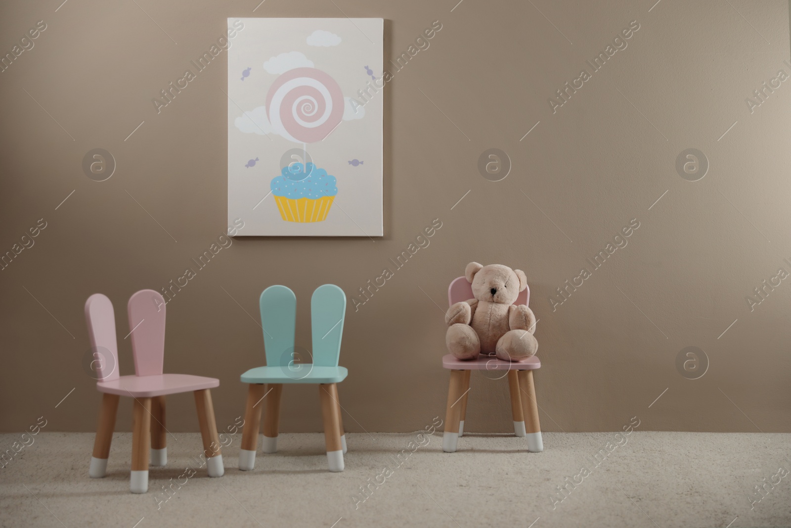 Photo of Cute chairs with bunny ears in children's room interior