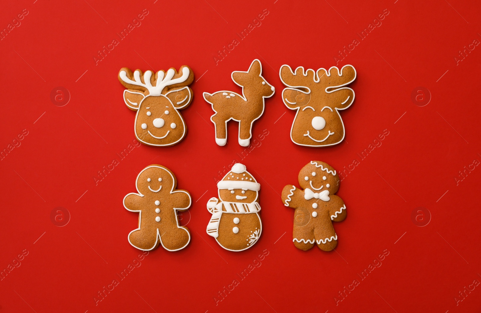 Photo of Different Christmas gingerbread cookies on red background, flat lay