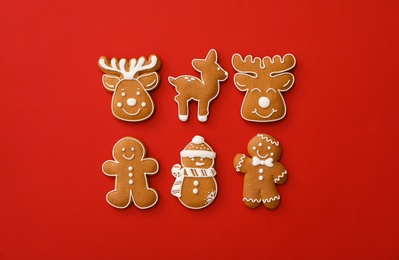 Different Christmas gingerbread cookies on red background, flat lay