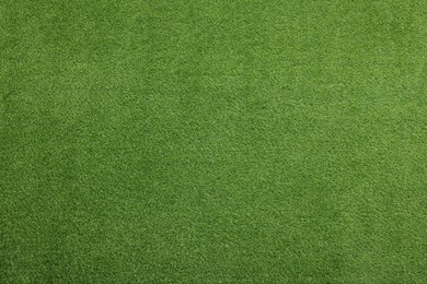 Green artificial grass as background, top view