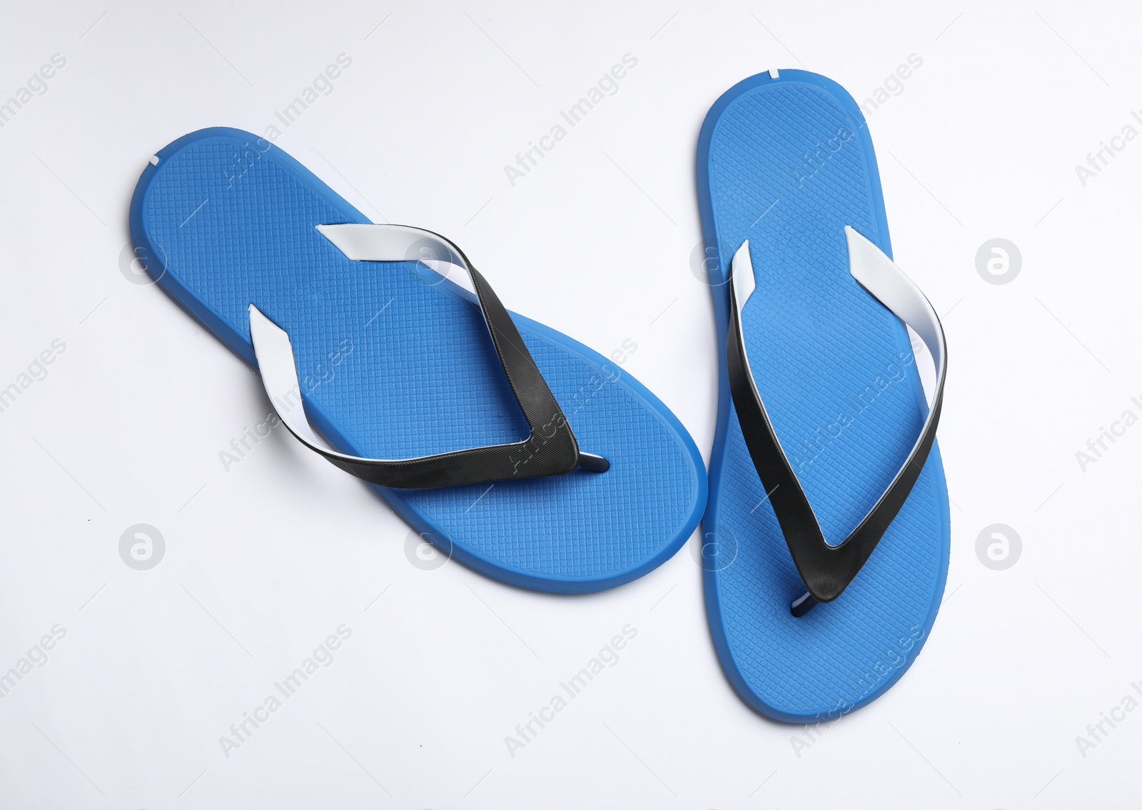 Photo of Pair of flip flops on white background, top view. Beach accessories