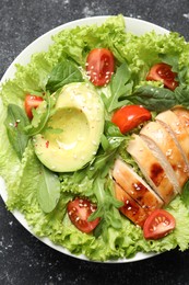 Photo of Delicious salad with chicken, cherry tomato and avocado on grey textured table, top view