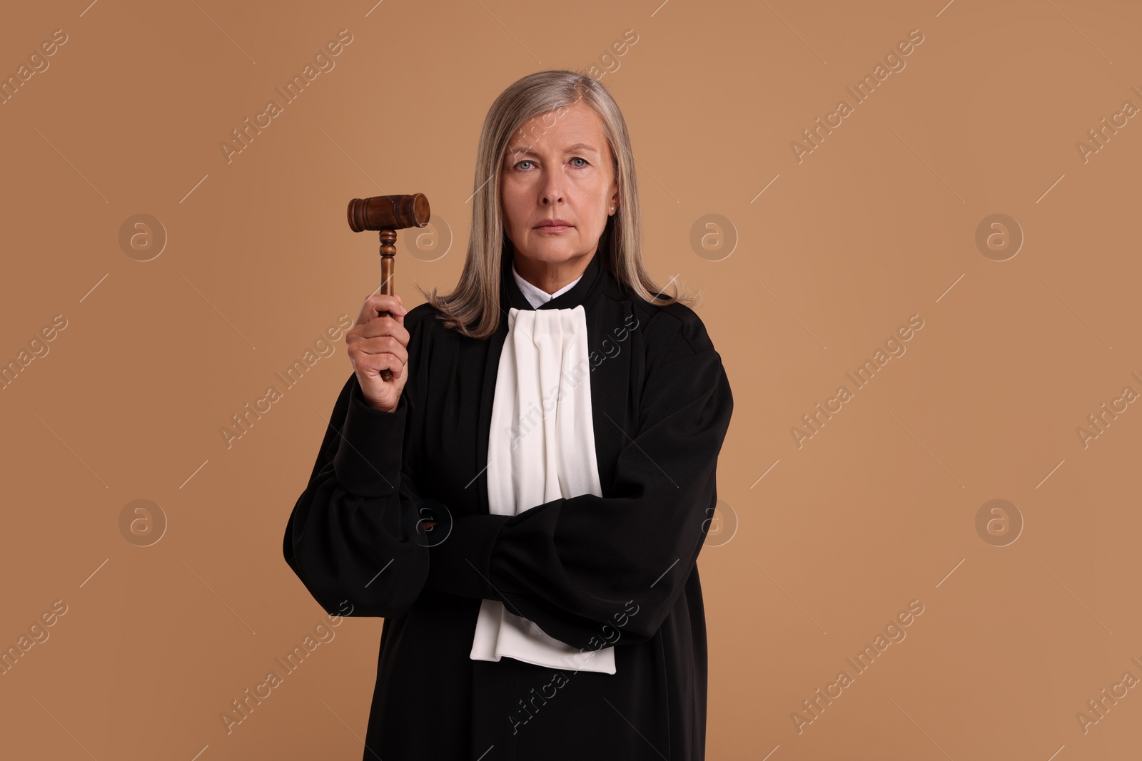 Photo of Senior judge with gavel on light brown background