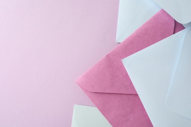 Photo of Colorful paper envelopes on pink background, flat lay. Space for text