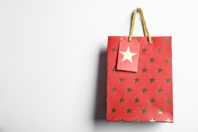 Photo of Red shopping paper bag with star pattern isolated on white