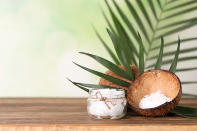 Photo of Composition with natural organic coconut oil on wooden table. Space for text