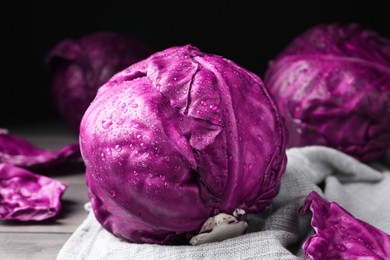 Photo of Wet red cabbage with water drops on wooden table, closeup