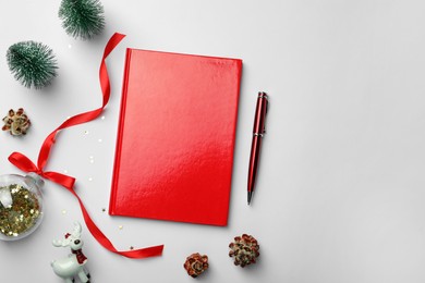 Photo of Red planner and Christmas decor on white background, flat lay with space for text. New Year aims