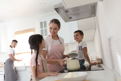 Happy family cooking together in kitchen at home