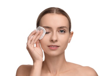 Photo of Beautiful woman removing makeup with cotton pad on white background