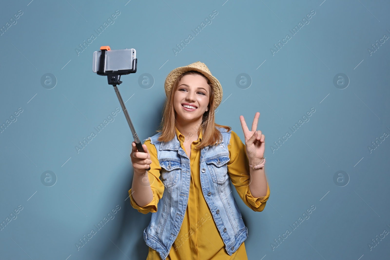 Photo of Attractive young woman taking selfie on color background