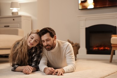 Photo of Lovely couple spending time together near fireplace at home