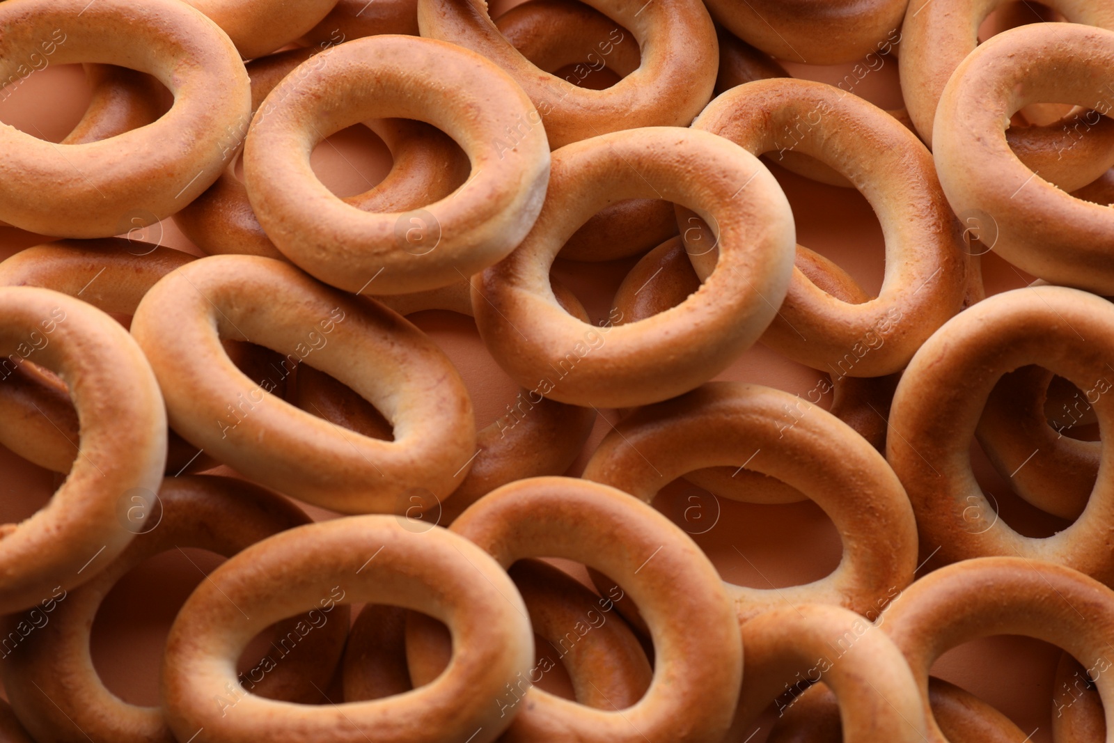 Photo of Many tasty dry bagels (sushki) as background, top view