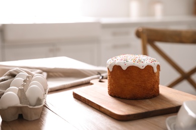 Photo of Traditional Easter cake on table in kitchen. Space for text