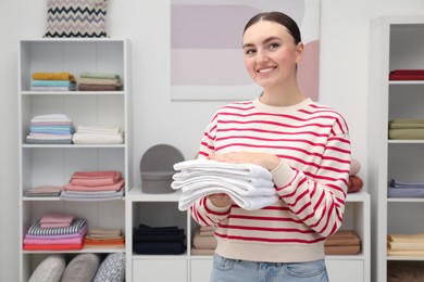 Photo of Smiling customer holding towels in home textiles store. Space for text