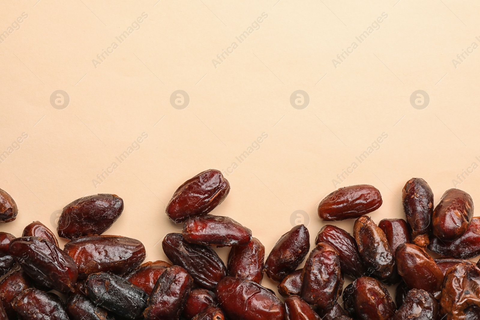 Photo of Sweet dried date fruits on color background, top view. Space for text