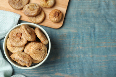 Photo of Tasty dried figs on light blue wooden table, flat lay. Space for text