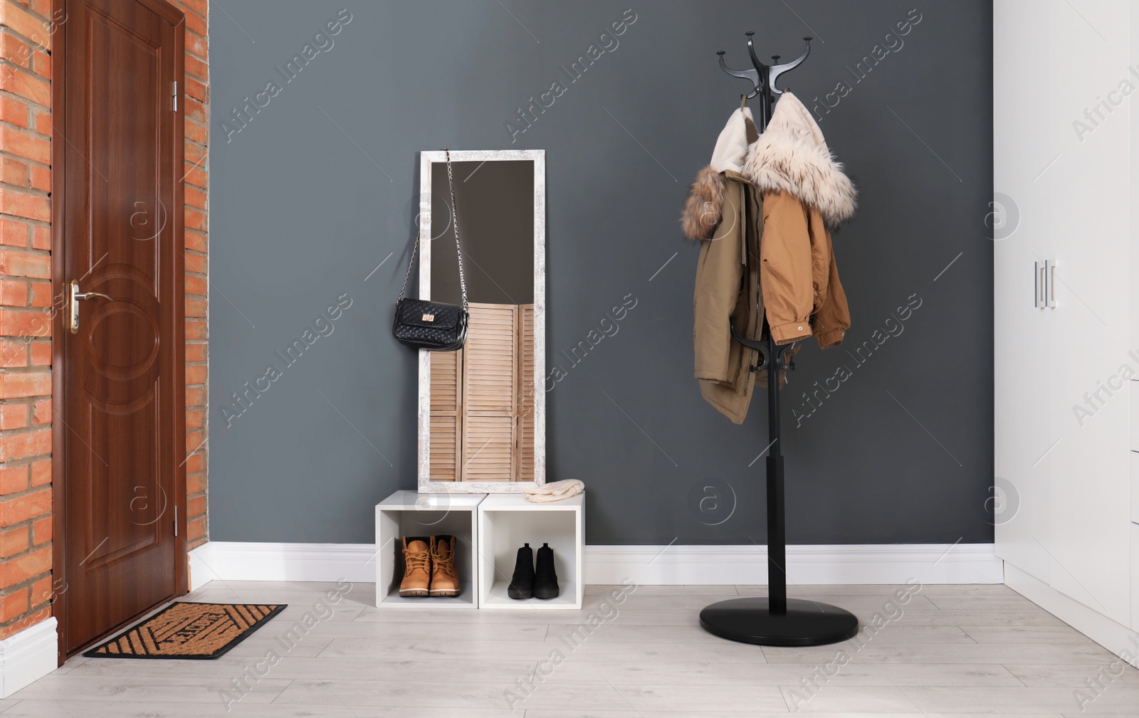Photo of Modern hallway interior with mirror and clothes on hanger stand