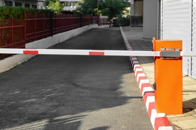 Photo of Closed boom barrier near road on sunny day outdoors