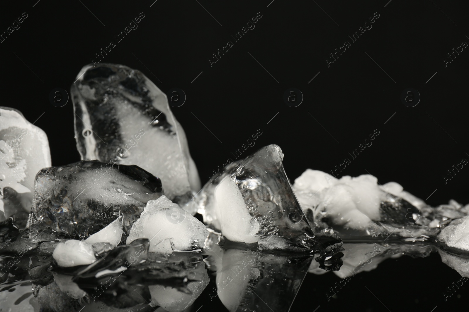 Photo of Pile of crushed ice on black mirror surface