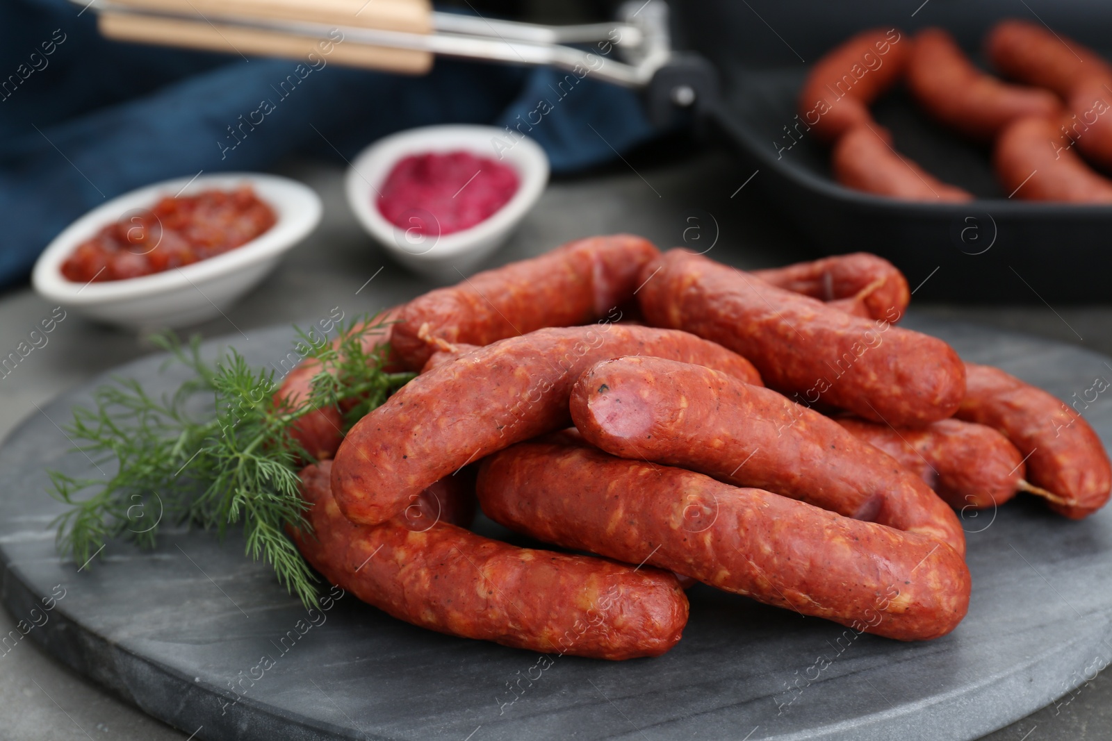 Photo of Delicious sausages and dill on grey table