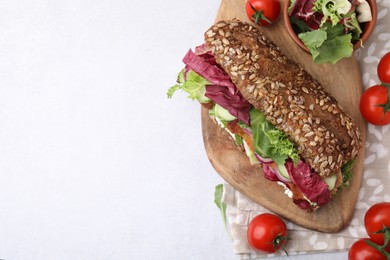 Photo of Delicious sandwich with schnitzel and ingredients on white table, flat lay. Space for text
