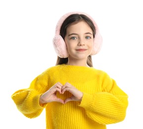 Cute girl in stylish earmuffs making heart with hands on white background