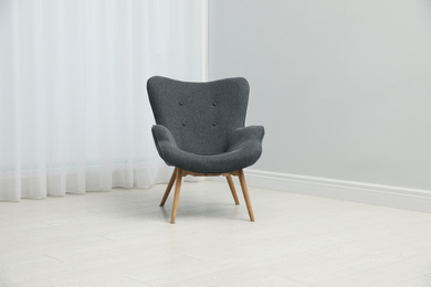 Comfortable armchair near window indoors. Stylish interior element