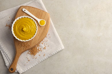 Photo of Tasty mustard sauce and dry seeds on light textured table, flat lay. Space for text