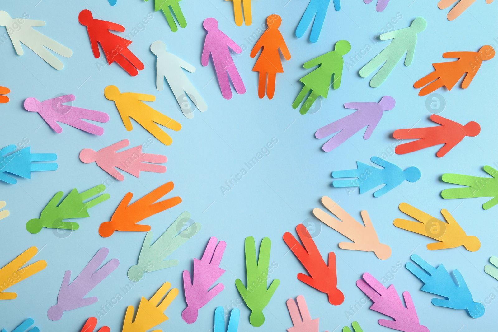 Photo of Frame of different paper human figures on light blue background, flat lay with space for text. Diversity and inclusion concept