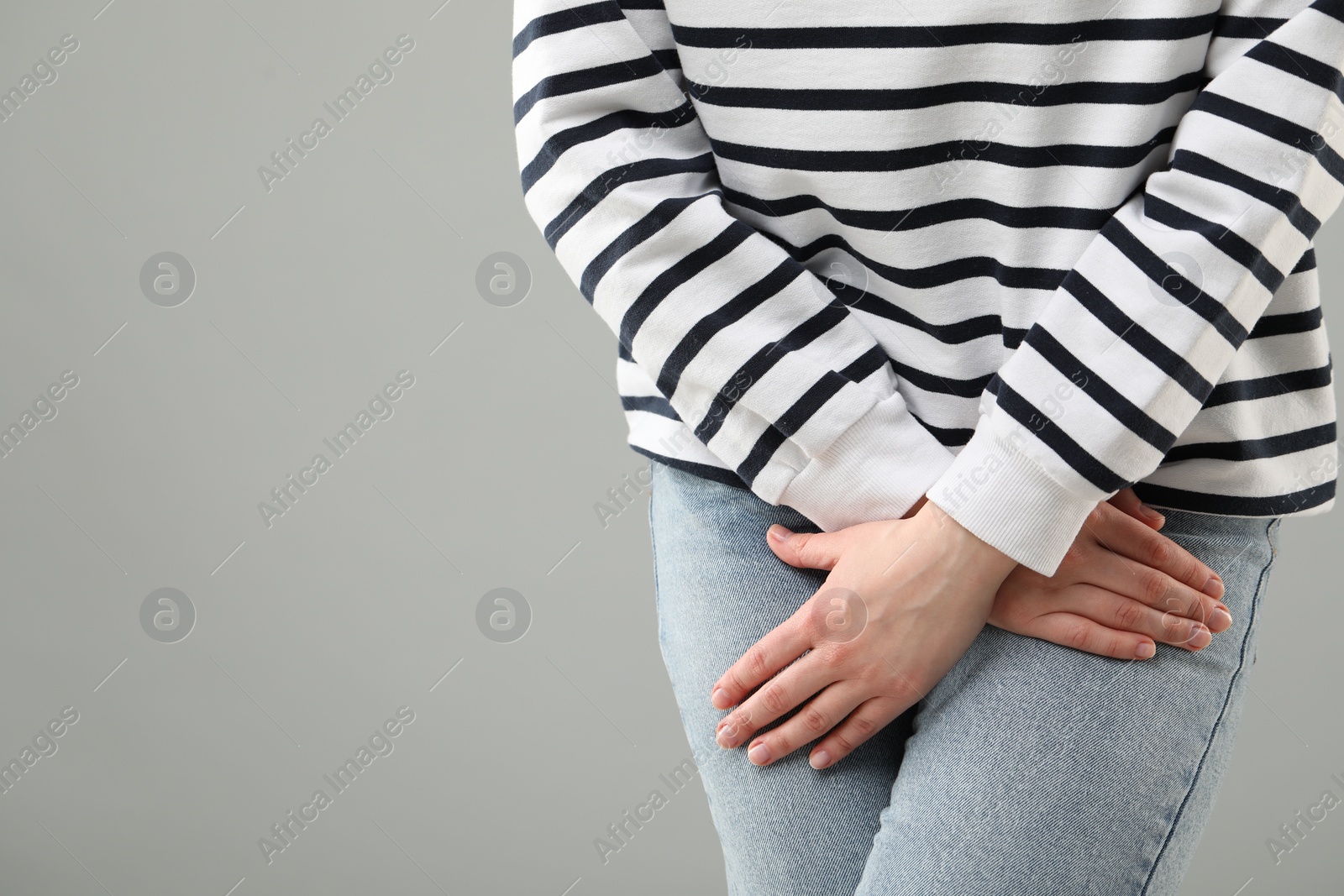 Photo of Woman suffering from cystitis on grey background, closeup. Space for text