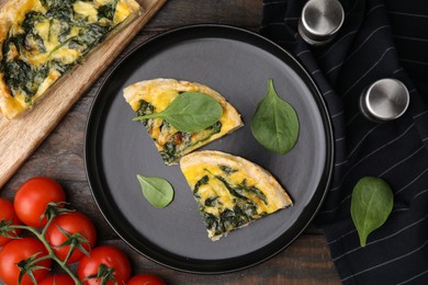 Photo of Pieces of delicious pie with spinach on wooden table, flat lay