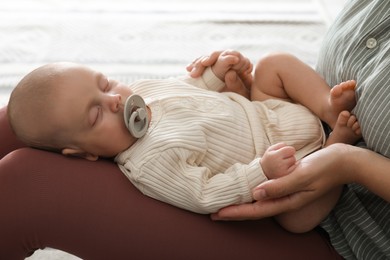 Mother with her cute sleeping baby at home, closeup