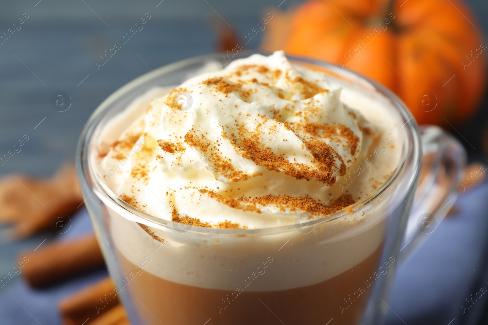 Photo of Delicious pumpkin latte on blue table, closeup