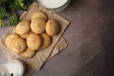 Photo of Tasty sweet sugar cookies, mint and milk on brown table, flat lay. Space for text