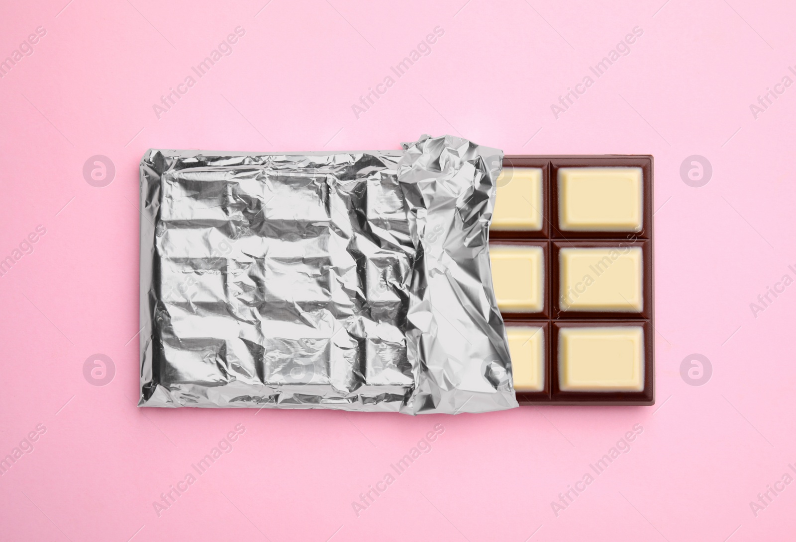 Photo of Tasty chocolate bar on pink background, top view