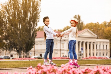 Happy children wearing roller skates on city street