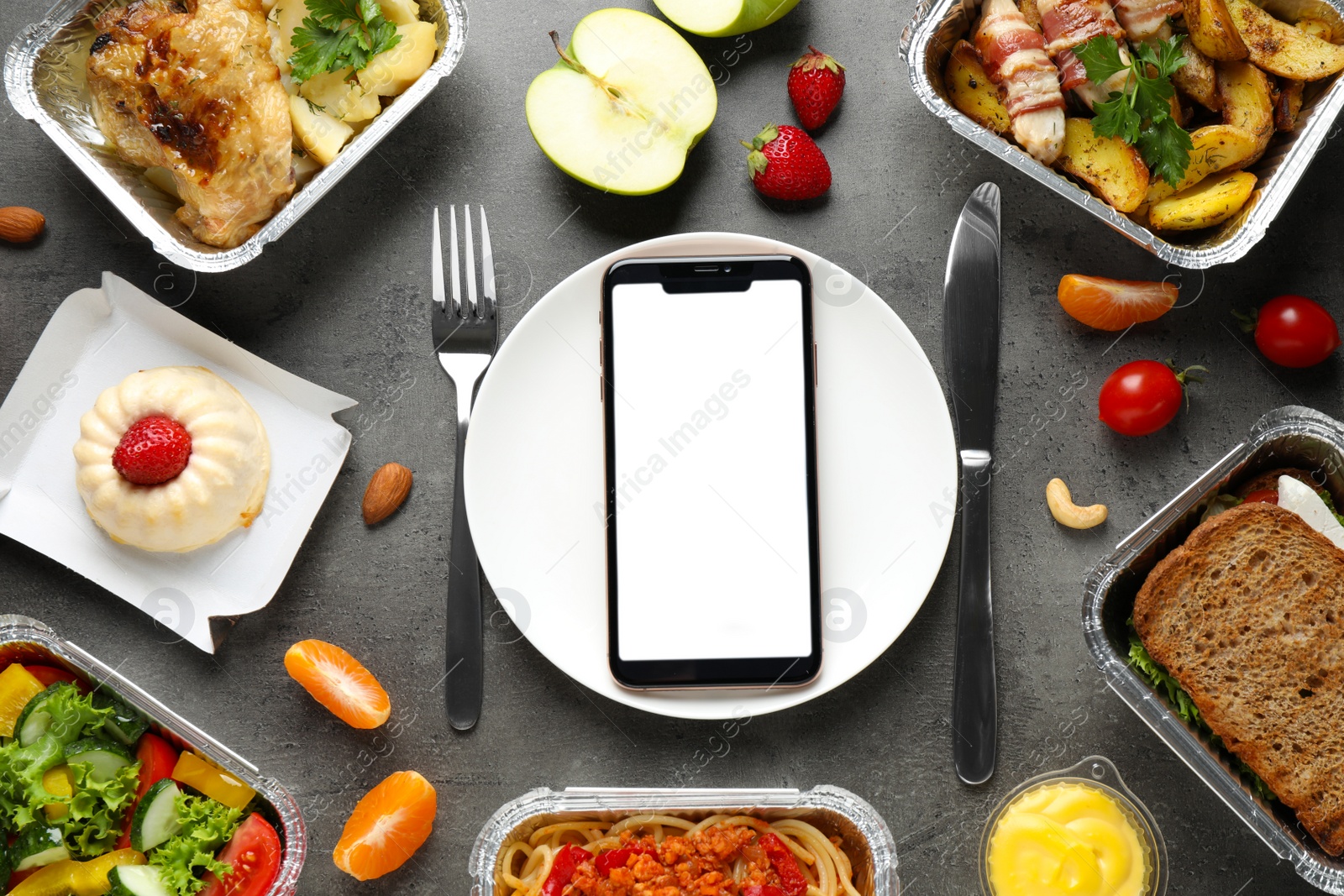 Photo of Flat lay composition with lunchboxes and smartphone on grey table, mockup for design. Healthy food delivery