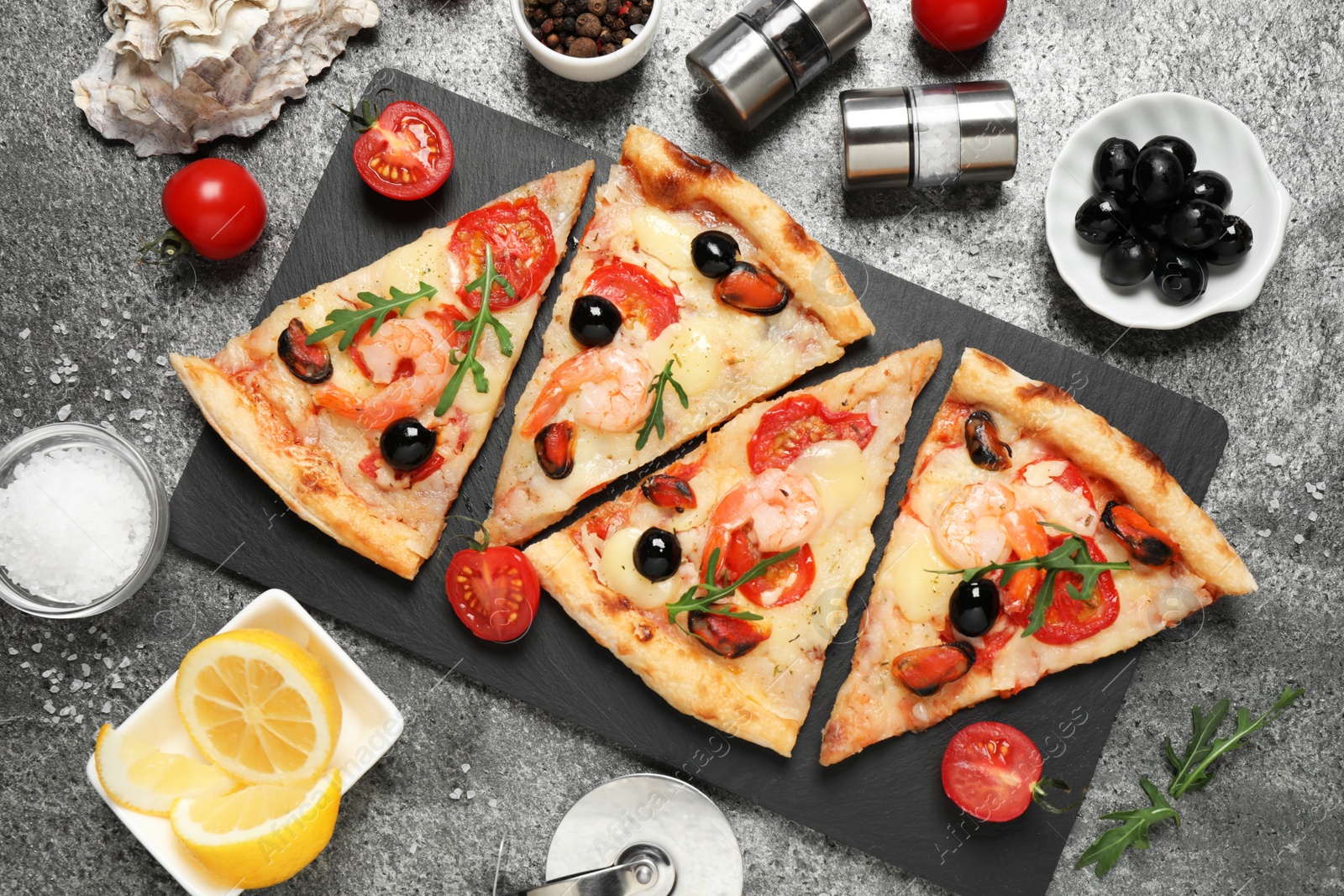 Photo of Tasty pizza with seafood and ingredients on grey table, flat lay