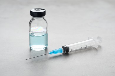 Photo of Syringe and vial on grey table. Medical anesthesia