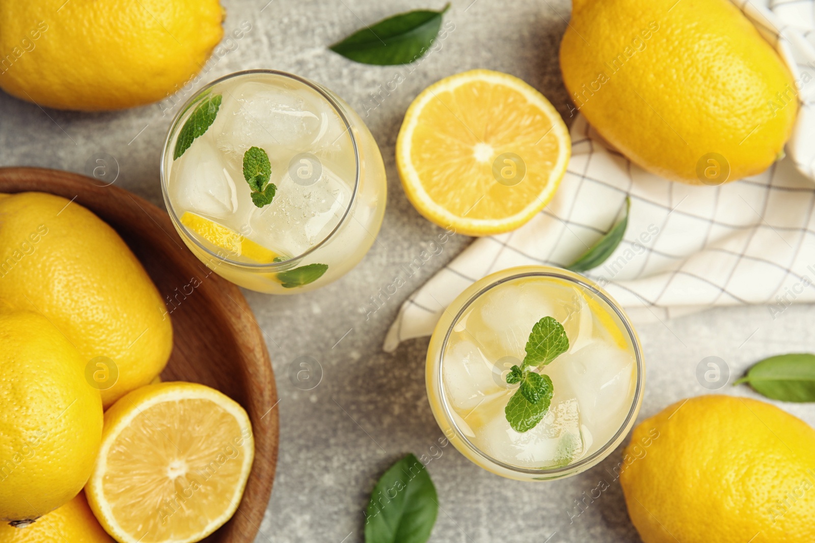 Photo of Cool freshly made lemonade and fruits on grey table, flat lay