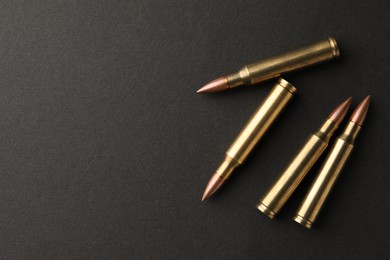 Photo of Bullets on black background, flat lay. Space for text