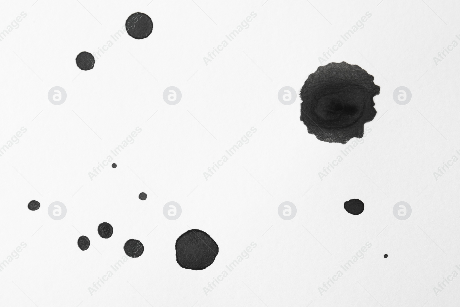 Photo of Blots of black ink on white background, flat lay