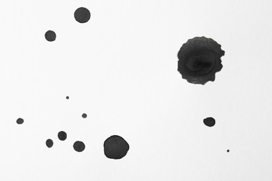 Photo of Blots of black ink on white background, flat lay