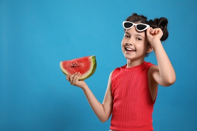 Cute little girl with watermelon on blue background